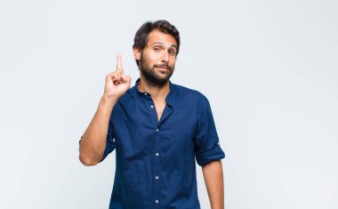 Genç Latin yakışıklı bir adam, harika bir fikri fark ettikten sonra parmağını kaldırıp 