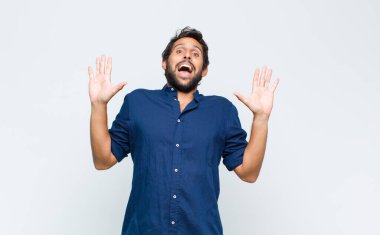 Genç Latin yakışıklı adam sersemlemiş ve korkmuş hissediyor, korkunç bir şeyden korkuyor, elleri açık ve uzak dur diyor.