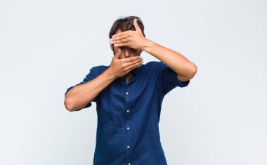 Genç Latin yakışıklı adam kameraya hayır diyen iki eliyle yüzünü kapatıyor! Resimler reddediliyor ya da yasaklanıyor