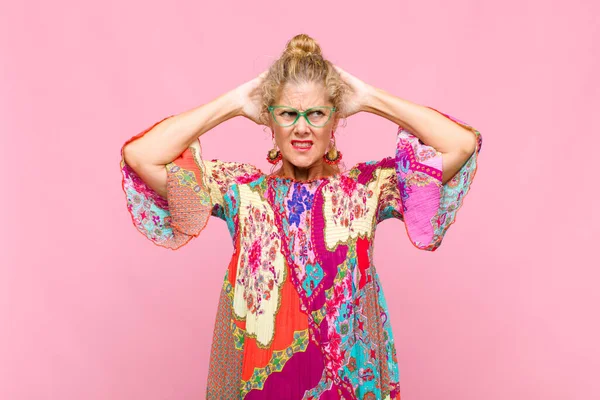 Orta yaşlı bir kadın stresli, endişeli, endişeli ya da korkmuş, elleri başının üstünde, hata yaptığında panikliyor.