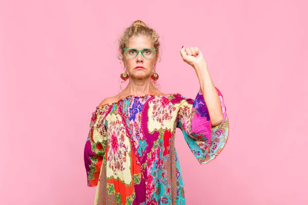 Orta yaşlı kadın ciddi, güçlü ve isyankar hissediyor, yumruğunu kaldırıyor, protesto ediyor ya da devrim için savaşıyor.