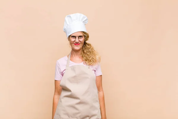中年の女性のパン屋は積極的かつ自信を持って笑顔で — ストック写真