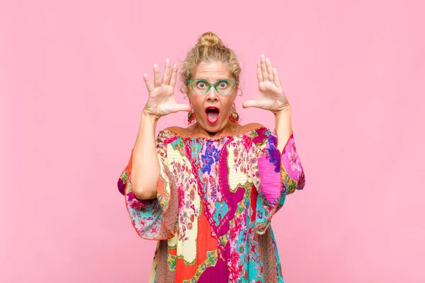 Orta yaşlı bir kadın elleri havada bağırıyor. Öfkeli, sinirli, stresli ve üzgün.