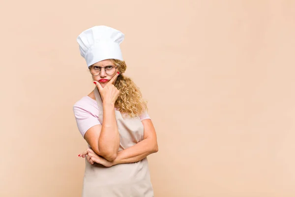 Жінка Середнього Віку Пекар Виглядає Серйозно Вдумливо Недовірливо Однією Рукою — стокове фото