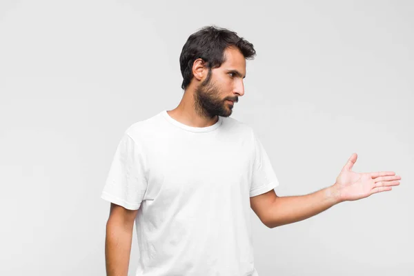 Junger Lateinischer Gutaussehender Mann Lächelt Begrüßt Sie Und Reicht Ihnen — Stockfoto