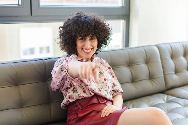 Kanepede oturan genç, güzel Arap kadın.