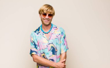 Sarışın, beyaz, utangaç ve neşeli bir adam, arkadaş canlısı, olumlu ama güvensiz bir tavırla gülüyor.