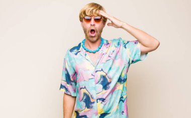 Sarışın, beyaz bir adam mutlu, şaşkın ve şaşırmış görünüyor, gülümsüyor ve inanılmaz ve inanılmaz iyi haberleri fark ediyor.