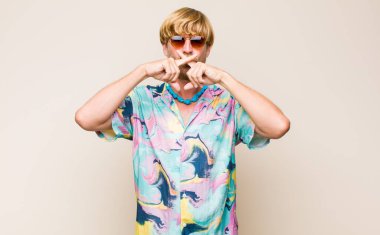 Sarışın, beyaz bir adam ciddi görünüyor ve iki parmağının önde olması hoşuna gitmiyor. Sessizlik istiyor.