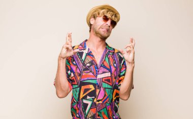 Sarışın yetişkin gezgin endişeyle parmaklarını çaprazlayarak ve endişeli bir bakışla iyi şanslar dileyerek.