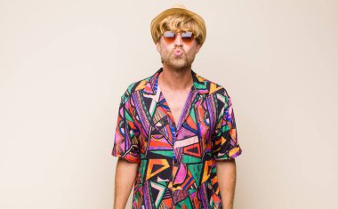 Sarışın, yetişkin bir gezgin tatlı, eğlenceli, mutlu, sevimli bir yüz ifadesiyle dudaklarını birbirine bastırıyor ve öpüşüyor.