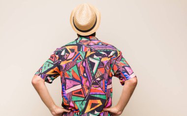 Sarışın, yetişkin, erkek, kafası karışık ya da şüpheci ve soru dolu, merak ediyor, elleri kalçasında, dikiz aynasından.