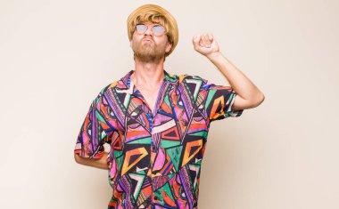 Sarışın, yetişkin, erkek, ciddi, güçlü ve asi, yumruğunu kaldıran, protesto eden ya da devrim için savaşan.