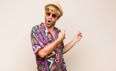 Sarışın, yetişkin, şaşkın ve şaşırmış hisseden erkek, yan taraftaki fotokopi alanını işaret ederek, şaşkın, açık ağızlı görünüm