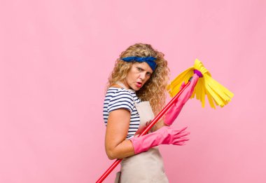 Pembe duvarda paspası olan orta yaşlı havalı bir kadın.