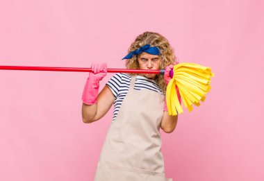 Pembe duvarda paspası olan orta yaşlı havalı bir kadın.