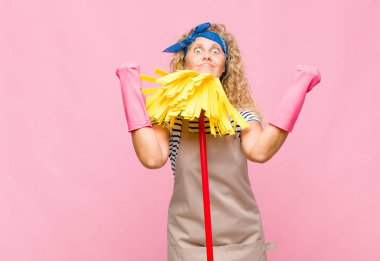 Pembe duvarda paspası olan orta yaşlı havalı bir kadın.