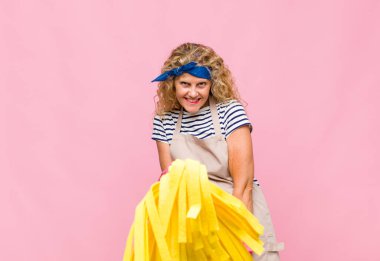 Pembe duvarda paspası olan orta yaşlı havalı bir kadın.