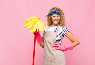 Pembe duvarda paspası olan orta yaşlı havalı bir kadın.