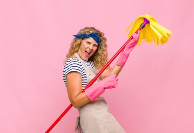 Pembe duvarda paspası olan orta yaşlı havalı bir kadın.