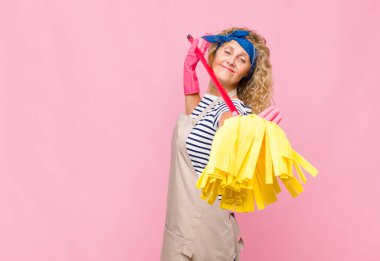 Pembe duvarda paspası olan orta yaşlı havalı bir kadın.