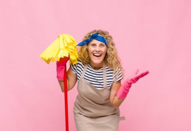 Pembe duvarda paspası olan orta yaşlı havalı bir kadın.