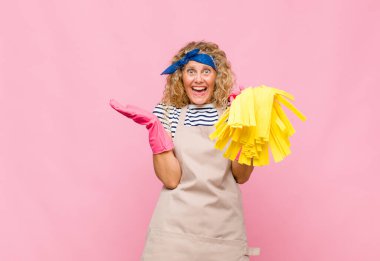 Pembe duvarda paspası olan orta yaşlı havalı bir kadın.