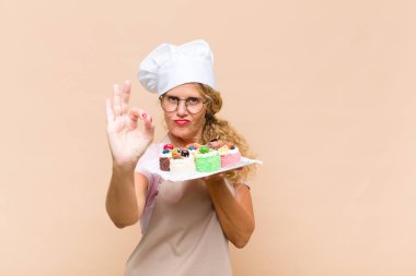 Orta yaşlı fırıncı kadın kek pişiriyor.