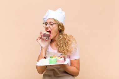 Orta yaşlı fırıncı kadın kek pişiriyor.