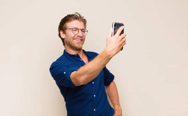 携帯電話を持つブロンドの大人の男 — ストック写真
