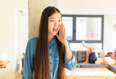 Genç, güzel Asyalı kadın profili görünüşü, mutlu ve heyecanlı görünüyor, bağırıyor ve kenardaki boşluğu kopyalamak için arıyor.