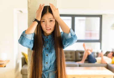 Genç ve güzel Asyalı kadın hayal kırıklığına uğramış ve sıkılmış hissediyor, başarısızlıktan bıkıp usanmış, sıkıcı işlerden bıkmış