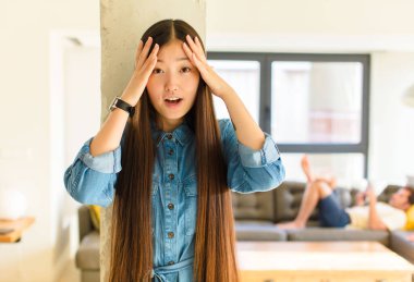 Genç, güzel Asyalı bir kadın dehşete kapılmış ve şok olmuş hissediyor. El ele tutuşuyor ve bir hata yüzünden panikliyor.