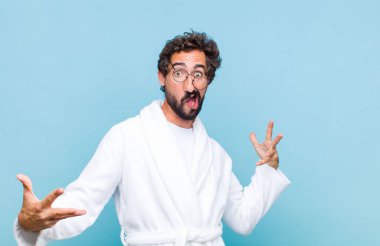 Banyo bornozu giyen genç sakallı adam mutlu, kibirli, gururlu ve kendini beğenmiş bir numara gibi hissediyordu.