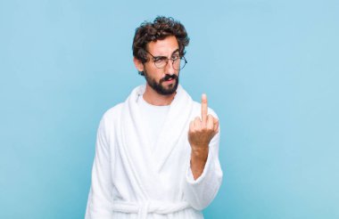 Genç sakallı bir adam banyoda bornoz giyer kızgın, sinirli, asi ve agresif hisseder, orta parmağını şaklatır, karşılık verir.