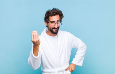 Bornoz giyen genç sakallı adam kapiş ya da para hareketi yaparak borçlarını ödemeni söylüyor.!