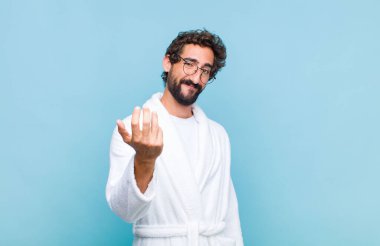 Banyo bornozu giyen genç sakallı adam kendini mutlu, başarılı ve kendinden emin hissediyor, bir meydan okumayla karşı karşıya ve 