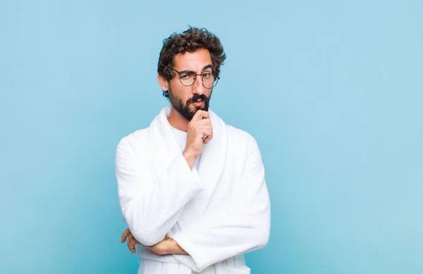 Young Bearded Man Wearing Bath Robe Looking Serious Confused Uncertain — Stock Photo, Image