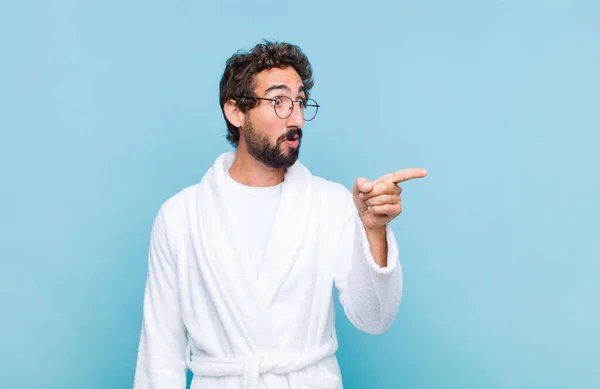 Giovane Uomo Barbuto Che Indossa Accappatoio Sensazione Scioccato Sorpreso Indicando — Foto Stock