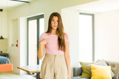 Kafası karışmış, kafası karışmış ve kendine güveni olmayan genç bir kadın kendini göstererek kim olduğunu soruyor, ben mi??