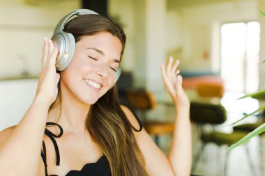 Genç, güzel bir kadın müzik dinliyor ve dans ediyor..