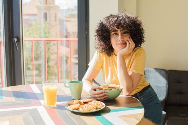 Genç ve güzel Arap kadın kahvaltısını evde yapıyor..