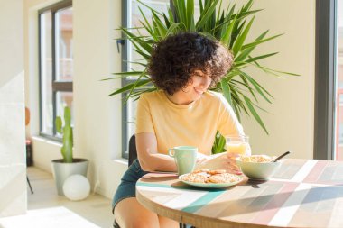 Genç ve güzel Arap kadın kahvaltısını evde yapıyor..