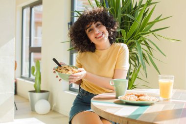 Genç ve güzel Arap kadın kahvaltısını evde yapıyor..