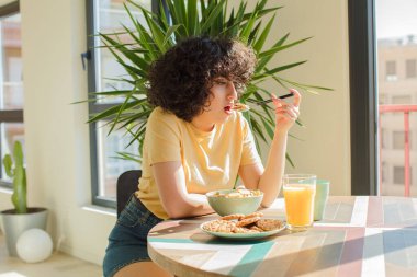 Genç ve güzel Arap kadın kahvaltısını evde yapıyor..