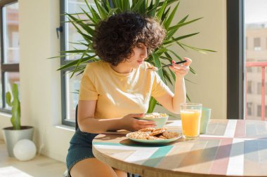 Genç ve güzel Arap kadın kahvaltısını evde yapıyor..