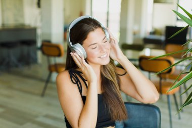 Genç, güzel bir kadın müzik dinliyor ve dans ediyor..