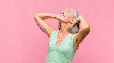 Orta yaşlı güzel bir kadın muzaffer bir şekilde bağırıyor. Heyecanlı, mutlu ve şaşırmış görünüyor. Kutlama yapıyor.