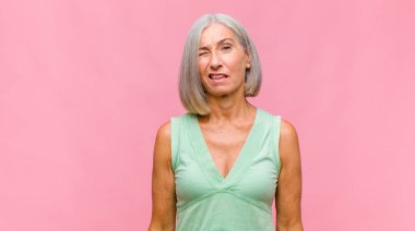 Orta yaşlı, güzel bir kadın mutlu, şaşkın ve gururlu, bağırıyor ve başarıyı büyük bir gülümsemeyle kutluyor.