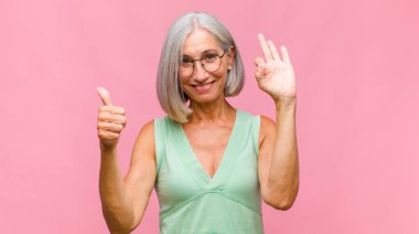 Orta yaşlı güzel bir kadın şaşkın, heyecanlı ve mutlu hissediyor, gülüyor ve başarıyı kutluyor,!